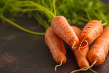 Raw carrots on a dark background, copy space.