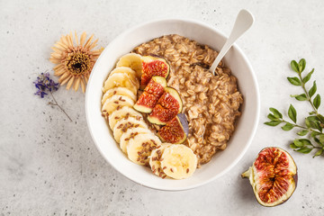 Autumn oatmeal with banana, fig and flax seed. White background, top view