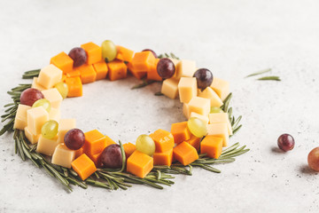 Christmas wreath of snacks from cheese and grapes. Christmas food background concept.