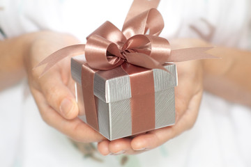 Closeup of woman hands holding a small gift box for special event.