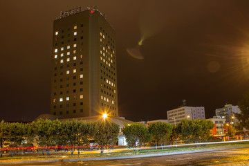 High building in night with car trail, long exposure