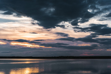 Naklejka na ściany i meble Sunset at the lake with sky reflecting in water