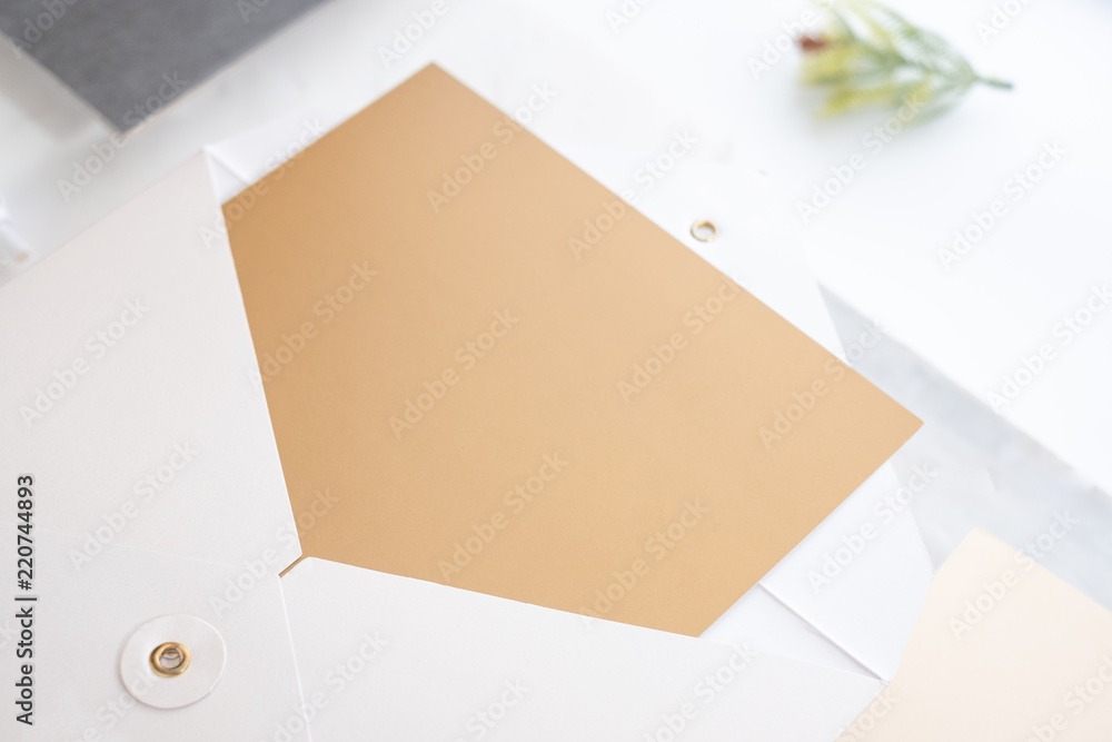 Poster Top view of blank gold card in white envelop with pine leaf on two layer step of marble table top.Mock up template for display of design .luxury business items.