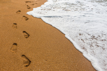 Footprints in the sand with sea background