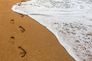 Footprints in the sand with sea background