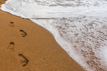 Footprints in the sand with sea background