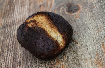 Verbranntes Brötchen auf Holztisch