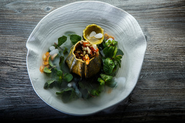 top view on dessert served in pumpkin decorated with mint and smoke