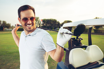 Portrait en gros plan d& 39 un homme souriant tout en tenant un club de golf