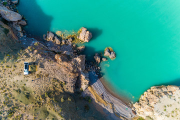 View from above, view from the air to the emerald sea with the beach and tourists by car