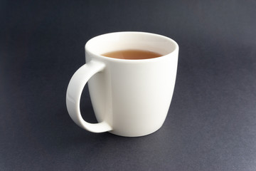 Cup of tea on dark background with selective focus and crop fragment