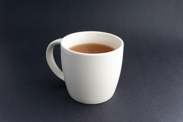 Cup of tea on dark background with selective focus and crop fragment