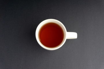 Cup of tea on dark background with selective focus and crop fragment