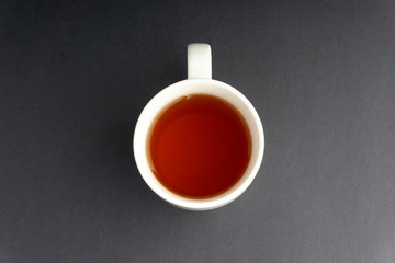 Cup of tea on dark background with selective focus and crop fragment