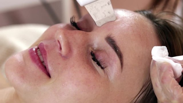 Ultrasonic face cleaning procedure. The work of beautician. Slowing down skin aging. Pore cleansing, black spots, oxygen saturation, dead skin cells.