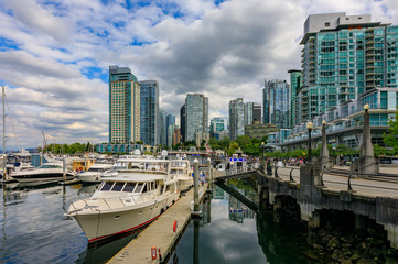 Coal Harbor in Vancouver British Columbia with downtown buildings boats and reflections in the water