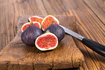 Group of whole and sliced ripe, delicious and sweets figs with a kitchen knife on a old rustic...