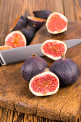 Group of whole and sliced ripe, delicious and sweets figs with a kitchen knife on a old rustic...