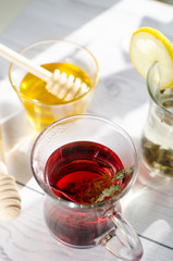 Refreshing herbal tea with honey is on the table by the window