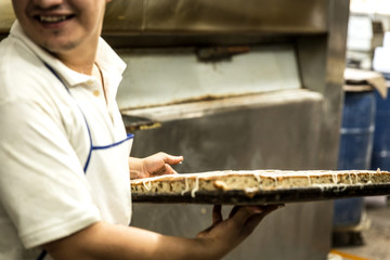 baker taking a tray of baked bread