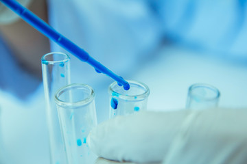 Close up. Medical or male medical in laboratory room research performs tests with blue liquid, Experimental Drug Treatment