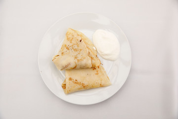 Obraz na płótnie Canvas Russian pancakes with sour cream