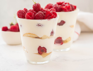 Raspberry dessert, cheesecake, raspberry tiramisu, trifle, mousse in a glass on a white background.