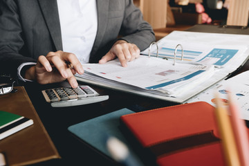businesswoman using a calculator to calculate the numbers for financial document, finance...
