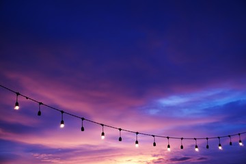 light bulb decor on string sunset sky on the beach