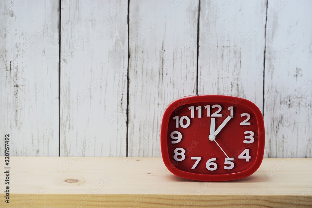 Poster red alarm clock with space for copy on wooden background