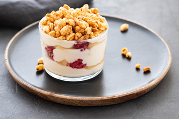 Fresh yoghurt with rasberry in clear glass. Raspberries in white bowl. Healthy morning breakfast.