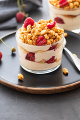 Fresh yoghurt with rasberry in clear glass. Raspberries in white bowl. Healthy morning breakfast.