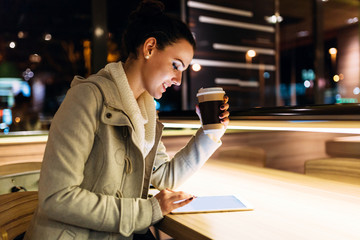 Attractive young woman using tablet in cafe