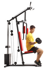 Young man exercising on a fitness machine with barbells isolated on white background