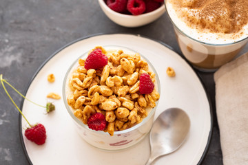 Fresh yoghurt with rasberries and coffee in clear glass. Raspberries in white bowl. Healthy morning breakfast.