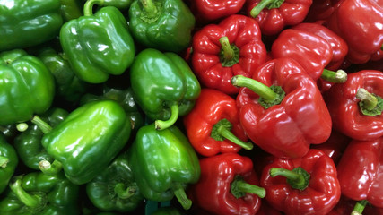 Obraz na płótnie Canvas Glossy green and red capsicum separated equally for each color