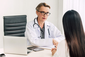 Doctor discussing and consulting with female patien on doctors table in hospital.healthcare and medicine