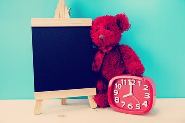 teddy bear and alarm clock with space copy on wooden background