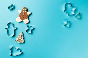 Christmas cookies various shape cutter on blue background with copy space. Top view. Flat lay. Trendy colorful photo. Minimal style with colorful paper backdrop. Christmas concept.