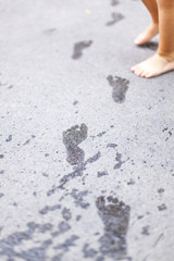 Fußabdruck von Kind auf Straße mit Wasser. Footprint with water from child on street.