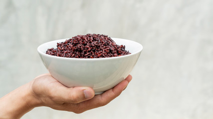 Men holding a riceberry in a white bowl.