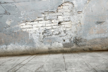 Ruined brick wall with dirty floor