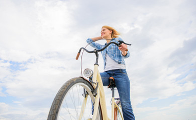 Girl rides bike sky background. Bike rental shops primarily serve people who do not have access to vehicle typically travellers and particularly tourists. Woman rent bike to explore city copy space