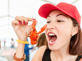 Young woman eating red boiled delicious crayfish or crawfish river lobster. Local cuisine and...