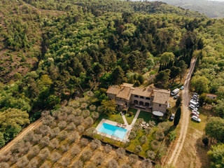 aerial view of villa with swimming pool near forest in Italy