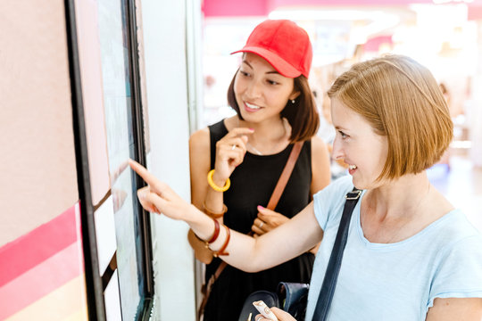 Two Friends Woman Using Automated Self-service Machine With Big Digital Touch Screen. Modern Technology Concept