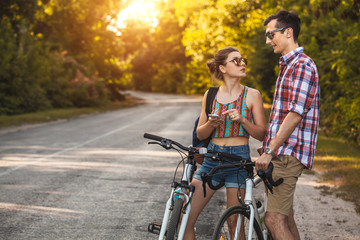 Obraz premium Young couple biking on a forest road in a sammer day