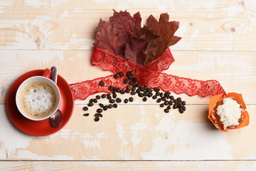 Cup of cappuccino coffee on wooden background with autumn leaves,