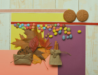 Brown leaves and colorful dragee, top view. Autumn colours concept.