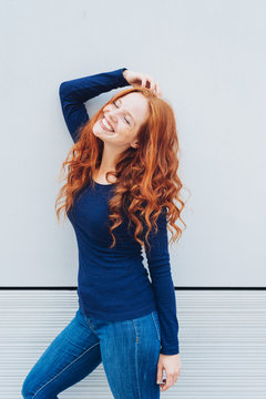 Slender sexy young woman with curly long red hair